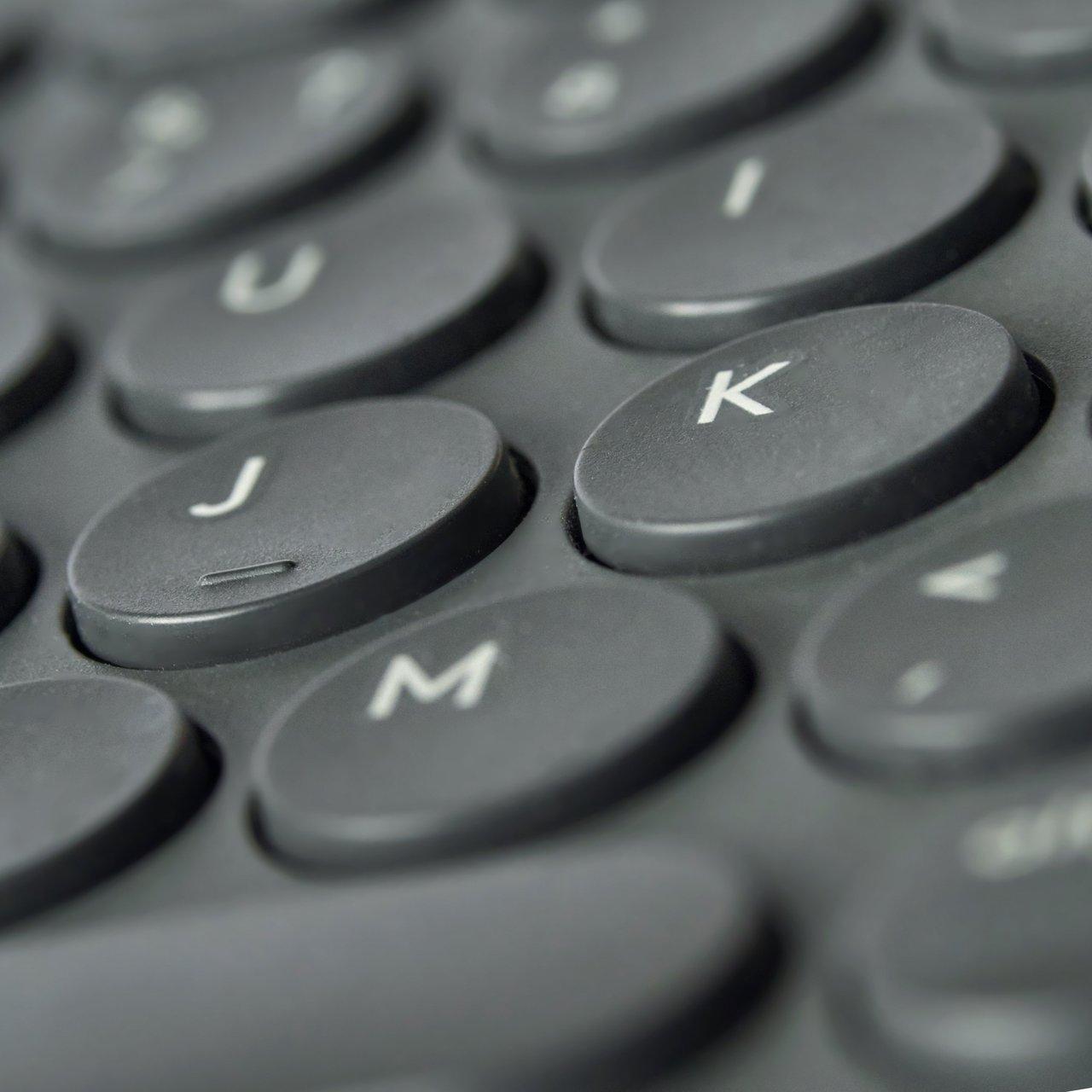 Clavier split ergonomique noir avec touches J, K et M, illustrant la séparation et le layout columnar.