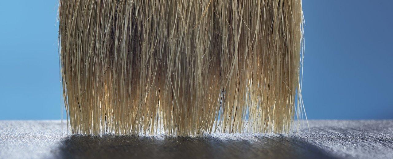 Détail d'un jazz drummer brushes close-up, soulignant la finesse du frottement sur la cymbale ride.