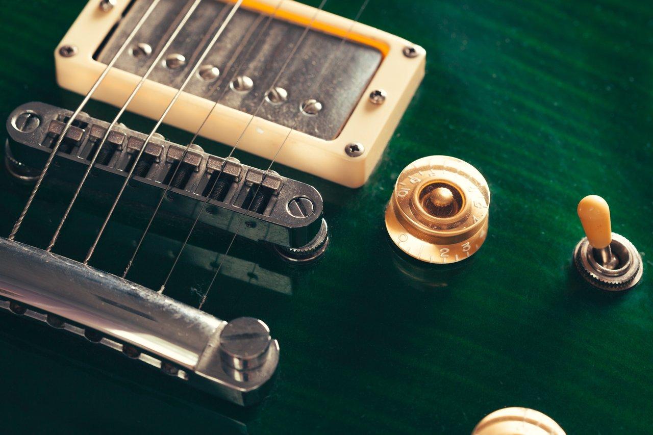 Détail en gros plan d’un réglage précis de l’intonation sur une electric guitar setup closeup pour riffs métal puissants.