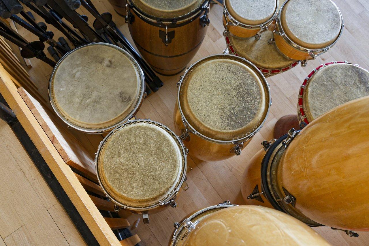 Set de percussion latine pour débutant, comprenant bongos, claves et shaker, avec peau usée et patine.