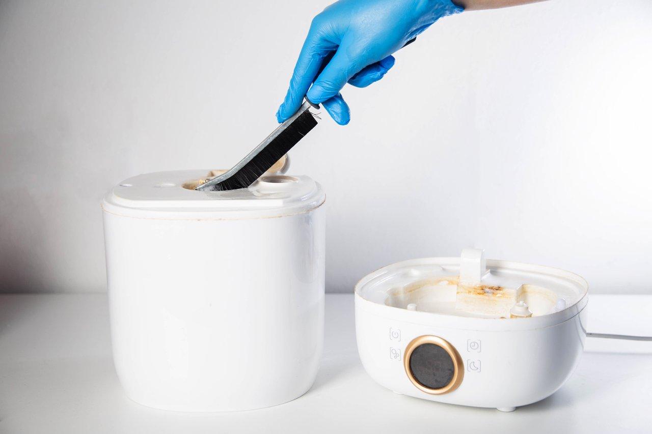 Technicien réalisant un nettoyage ultrason de la sourdine cuivre pour trompette avec un ultrasonic cleaning trumpet mute.