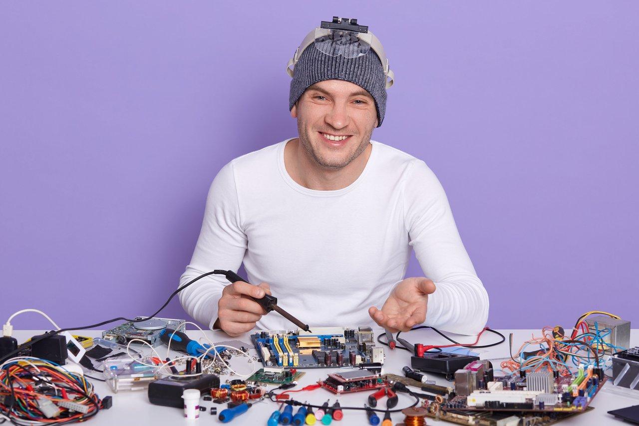Technicien spécialisé en remplacement de lampes de guitare amp tube lors d'une intervention en atelier.