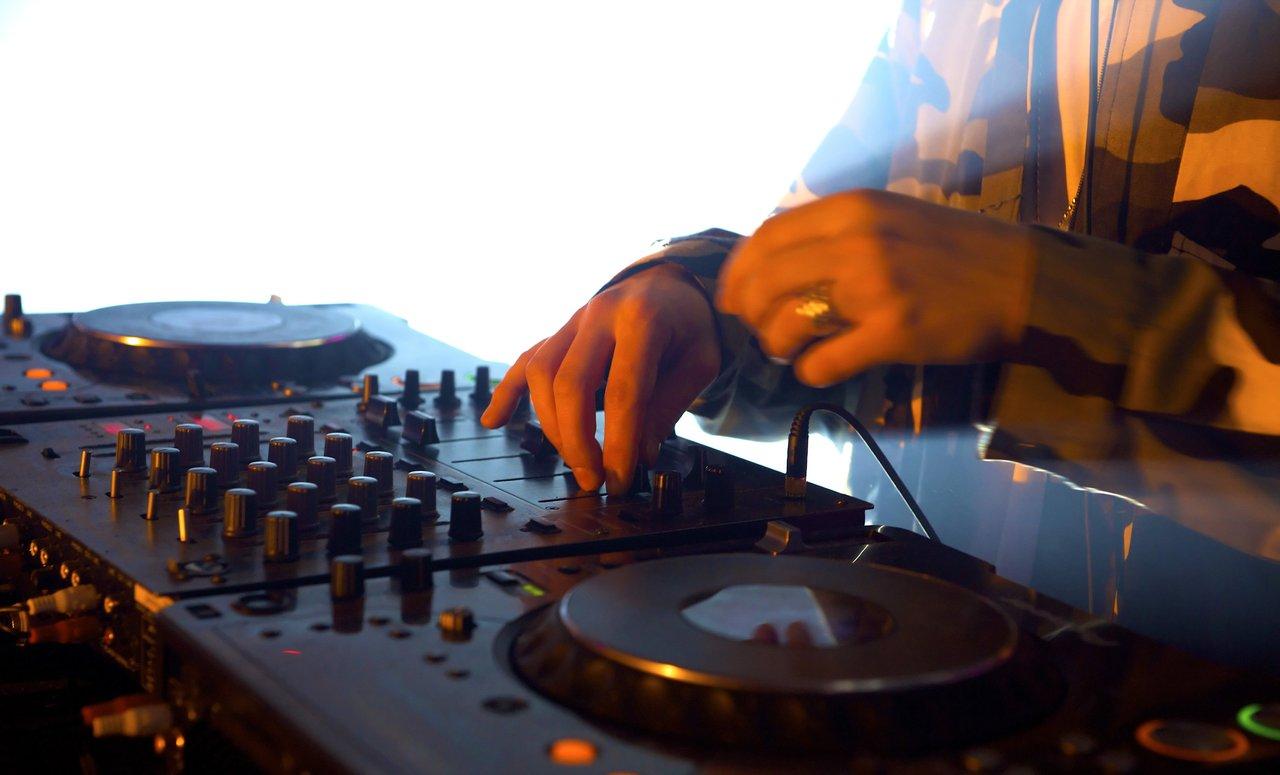 Une performance DJ scratch sur une platine Technics SL-1210GR2, mettant en valeur le bras, le plateau et le slipmat.