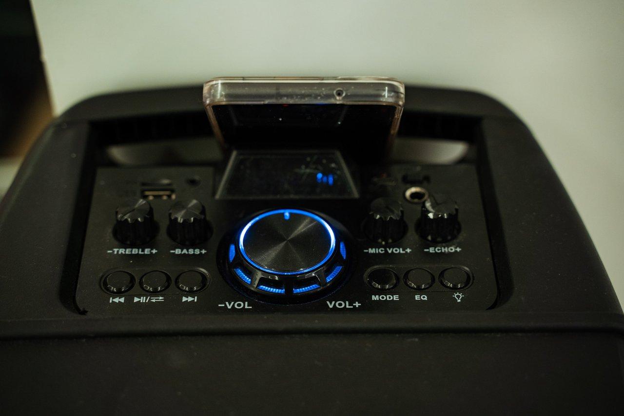 Vue rapprochée d’un mixer de haut-parleur portable, avec ses contrôles lumineux et interface compacte.